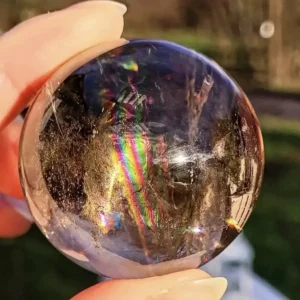 Polished smoky quartz sphere with visible internal rainbows and high clarity