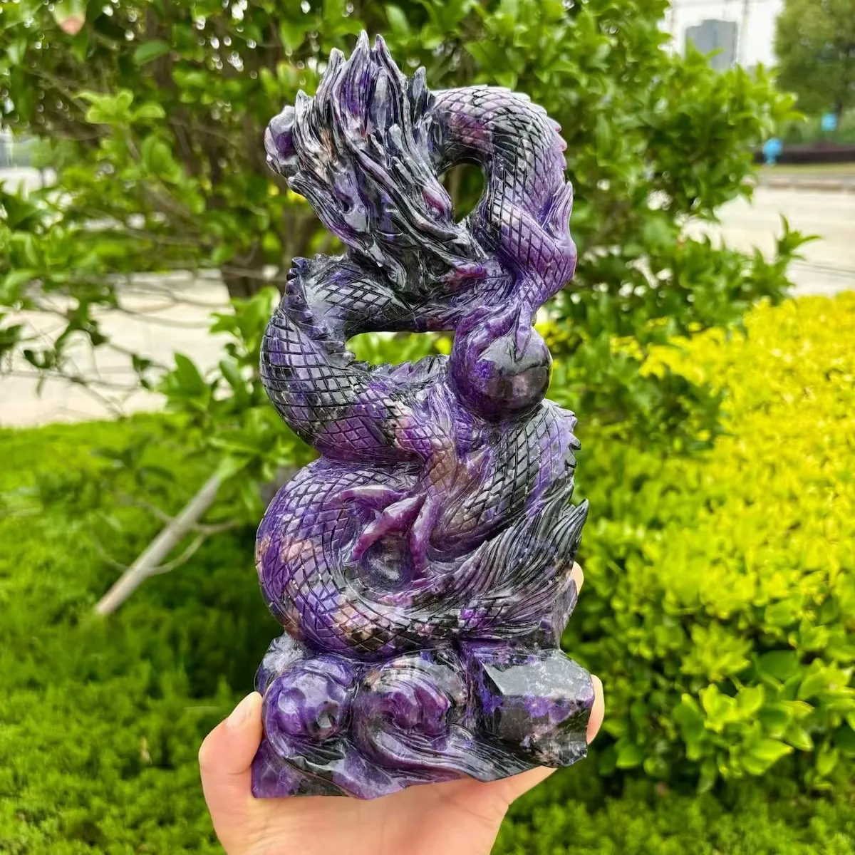 Handmade purple charoite dragon carving with a curling tail and detailed scales